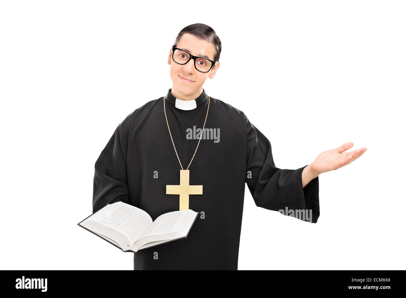 Giovane sacerdote cattolico tenendo una bibbia e gesticolando con la sua mano isolati su sfondo bianco Foto Stock