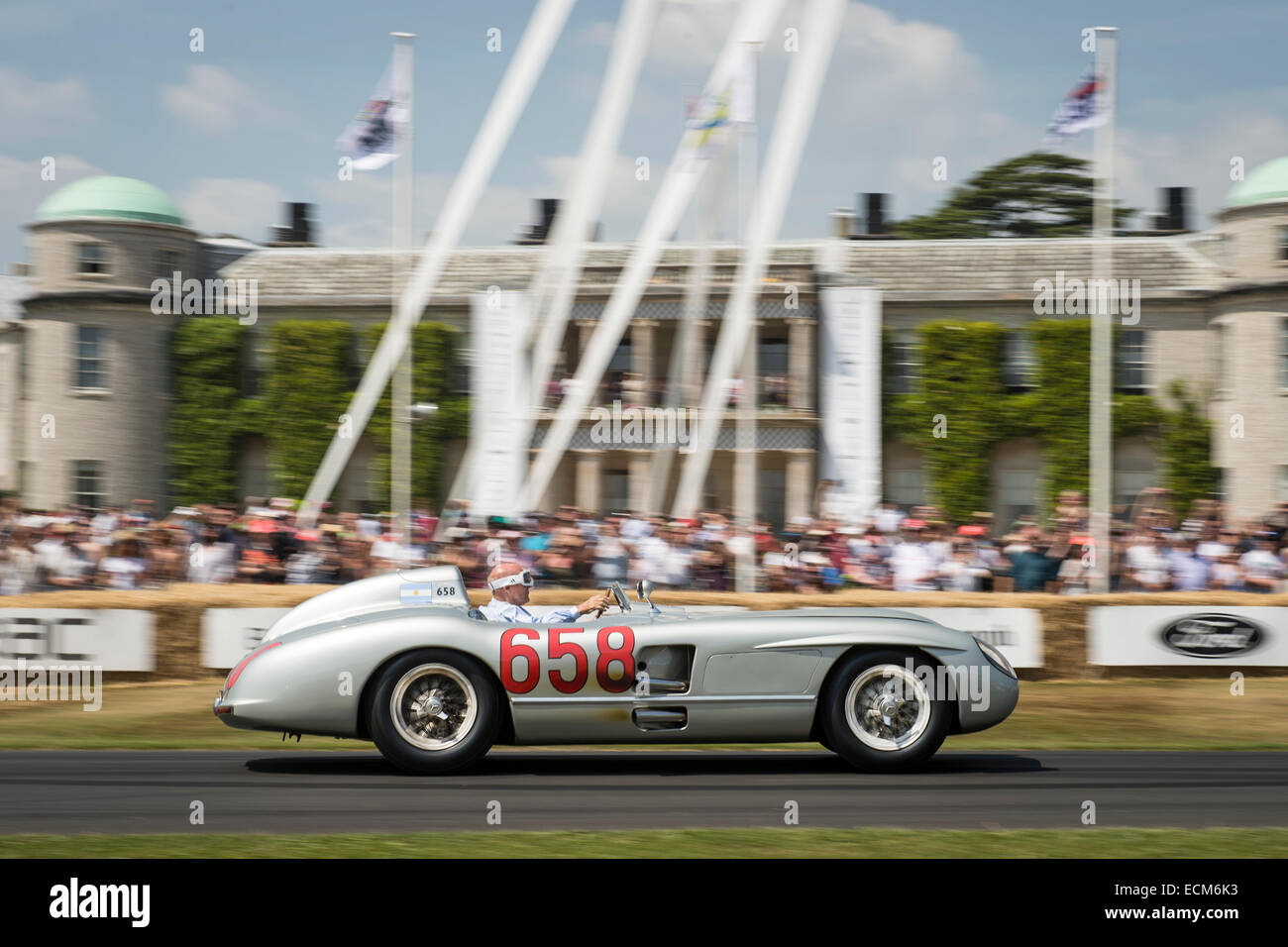 Stirling Moss alla guida di una Mercedes-Benz passato Goodwood House Foto Stock