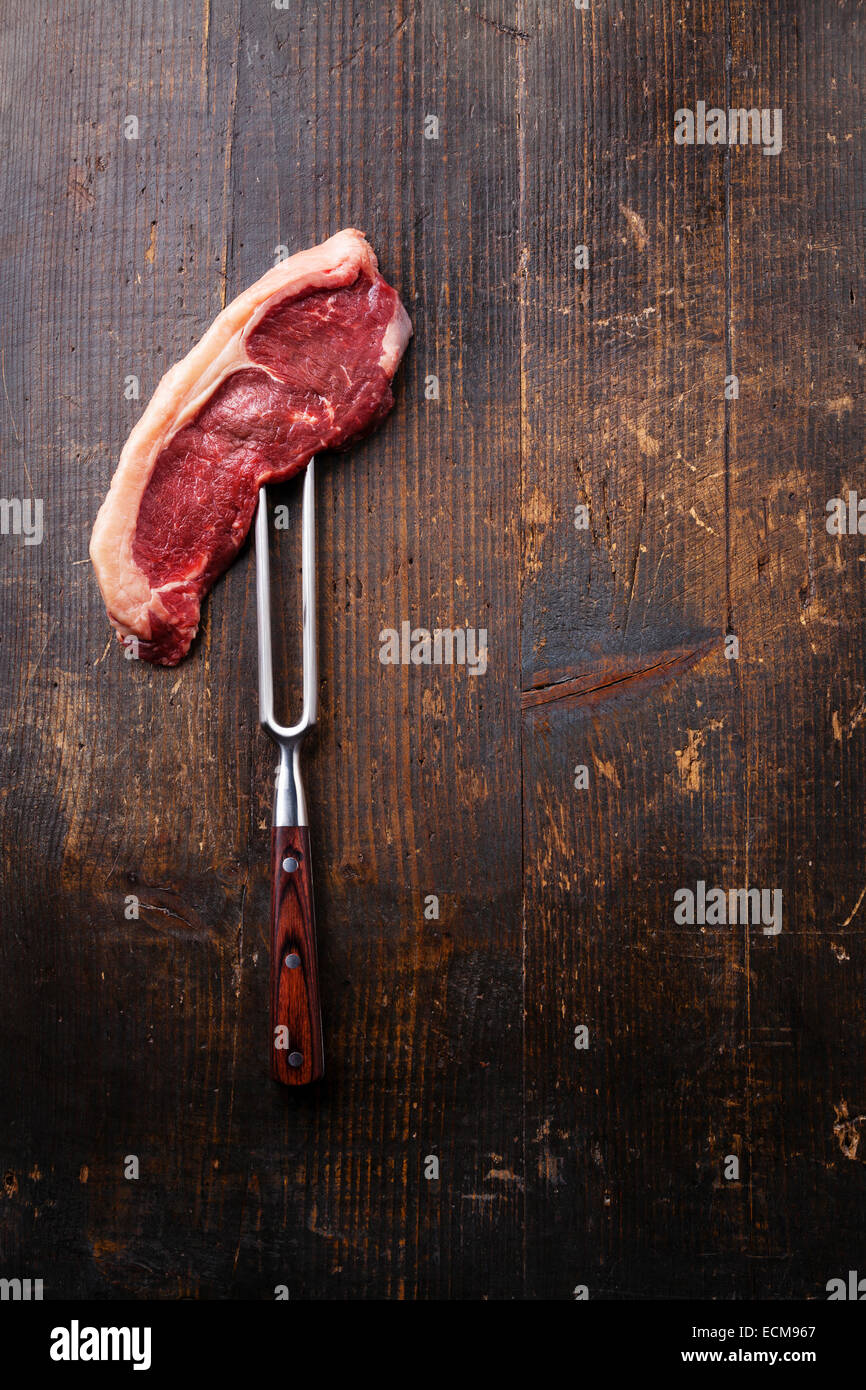 Materie carni fresche bistecca di controfiletto di carne forcella sul legno scuro dello sfondo Foto Stock