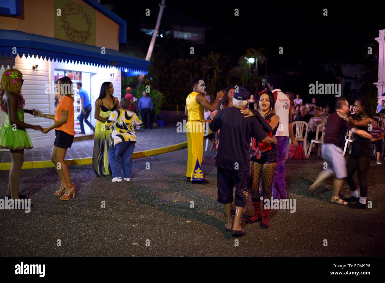 Gli ospiti e il personale a ballare merengue musica in un Resort outdoor street party Puerto Plata Repubblica Dominicana Foto Stock