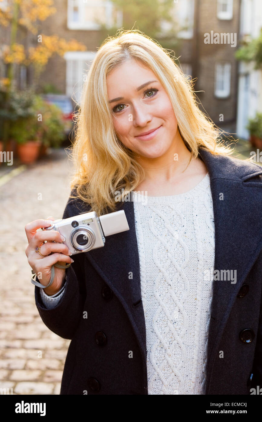 Giovane donna in possesso di una telecamera Foto Stock