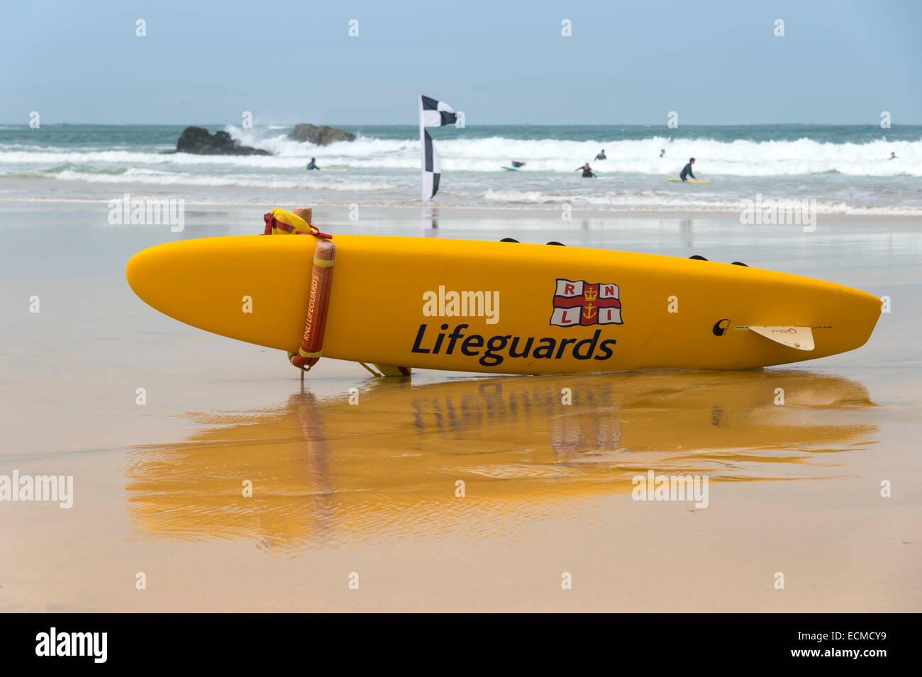 Un giallo con la tavola da surf di bagnini è sdraiato sulla spiaggia, canale inglese, Polperro, Cornwall, England, Regno Unito Foto Stock