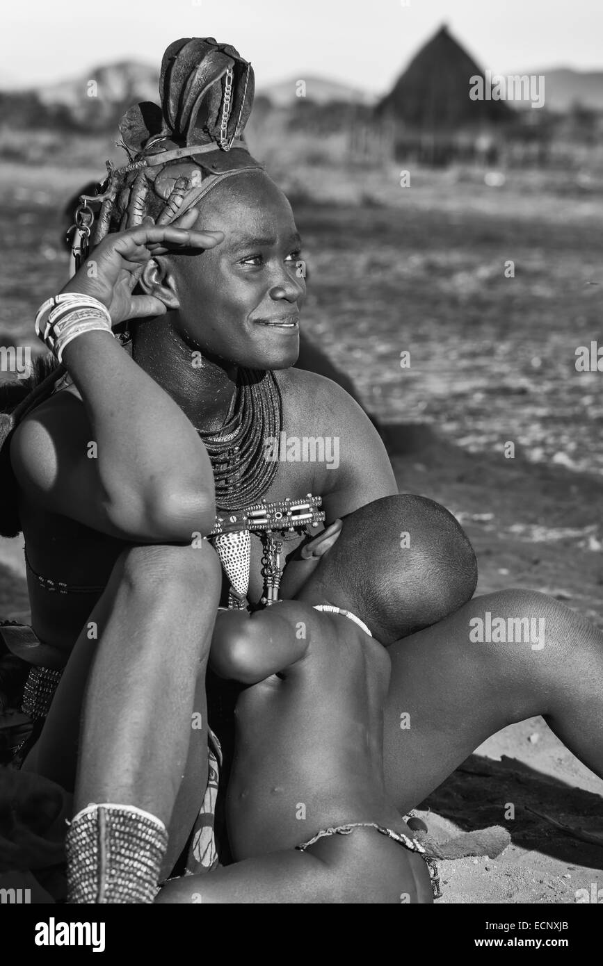 Donna Himba alimentando il suo bambino Foto Stock