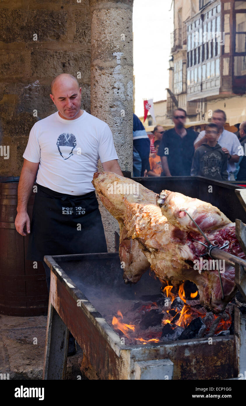 TORO (Zamora), Spagna - 13 ottobre 2012: un uomo cucinare e servire un maiale su un arrosto allo spiedo alla vendemmia festival, su Octob Foto Stock