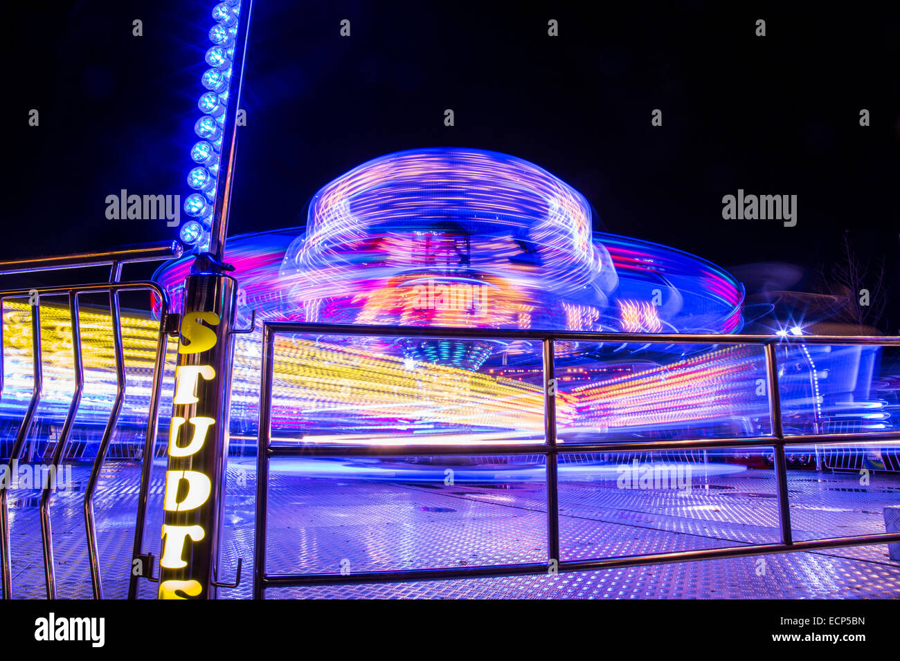 Fiera giostre a Aberystwyth annuale Fiera di Natale la filatura nella notte illuminata dal lampeggiante e luce colorata Foto Stock