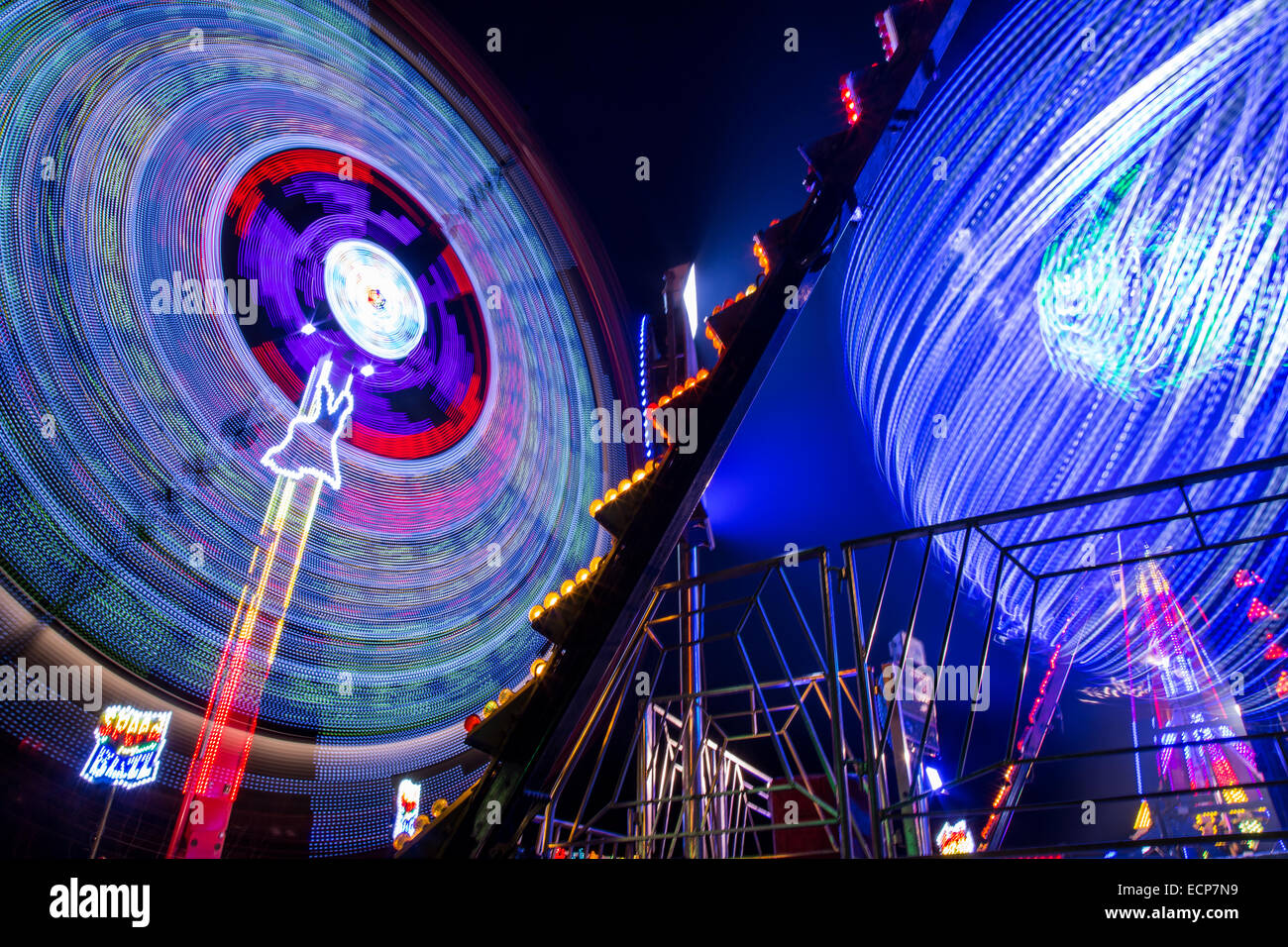 Fiera giostre a Aberystwyth annuale Fiera di Natale la filatura nella notte illuminata dal lampeggiante e luce colorata Foto Stock