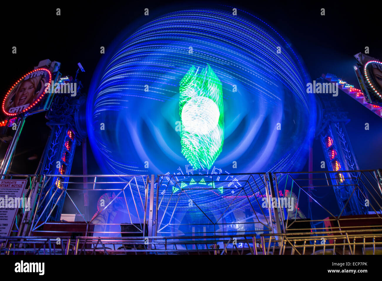 Fiera giostre a Aberystwyth annuale Fiera di Natale la filatura nella notte illuminata dal lampeggiante e luce colorata Foto Stock