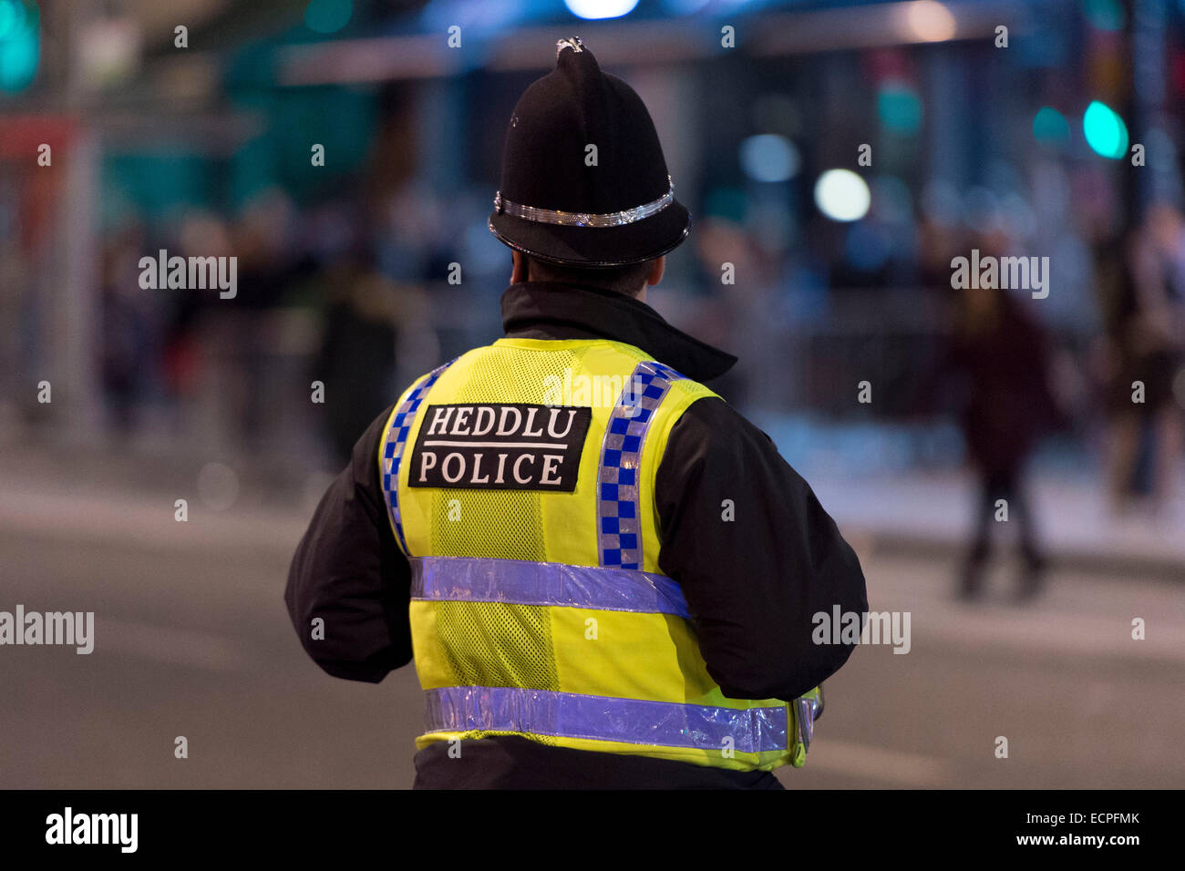Un poliziotto di pattuglia di notte nel centro di Cardiff. Centinaia di buontemponi sono fuori durante il fine settimana di bere alcolici. Foto Stock