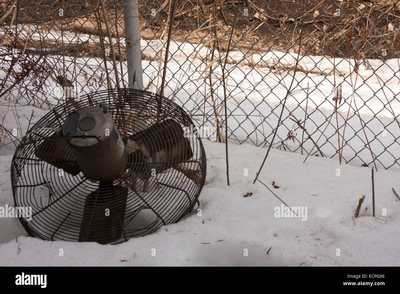 Un ventilatore industriale recante nella neve in un capannone industriale abbandonato Foto Stock