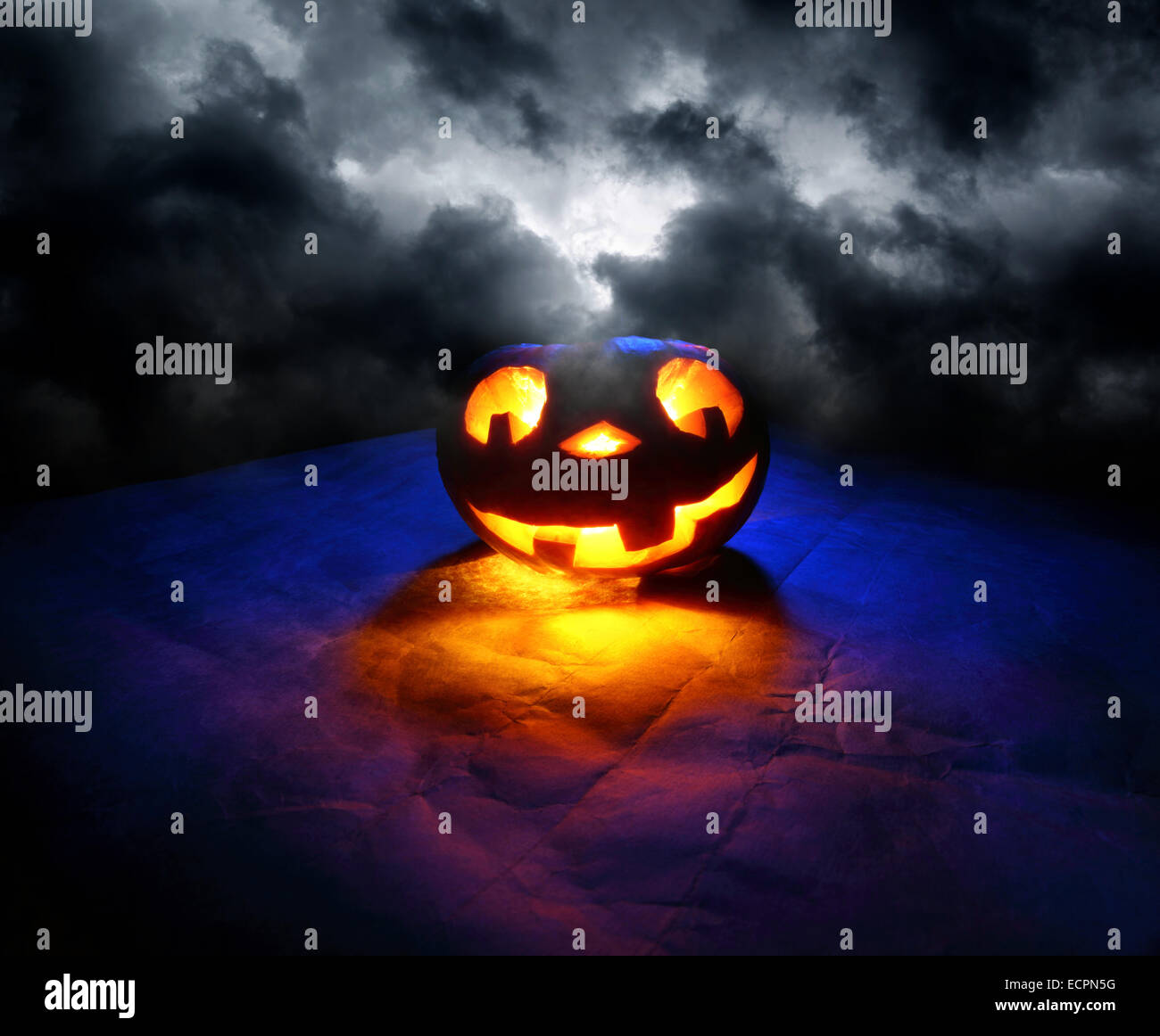 Divertenti Zucca di Halloween in luce blu a cielo scuro Foto Stock