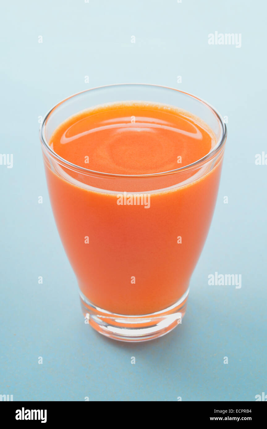 La carota e Apple appena premuto il succo in vetro su uno sfondo chiaro. Un sano materie prime vegetali e frutta bevanda per la sana prima colazione Foto Stock