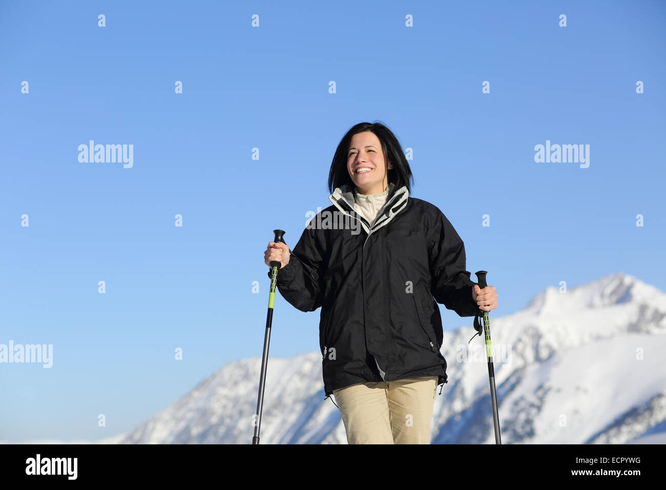 Funny escursionista woman trekking in montagna con il cielo e una montagna innevata in background Foto Stock