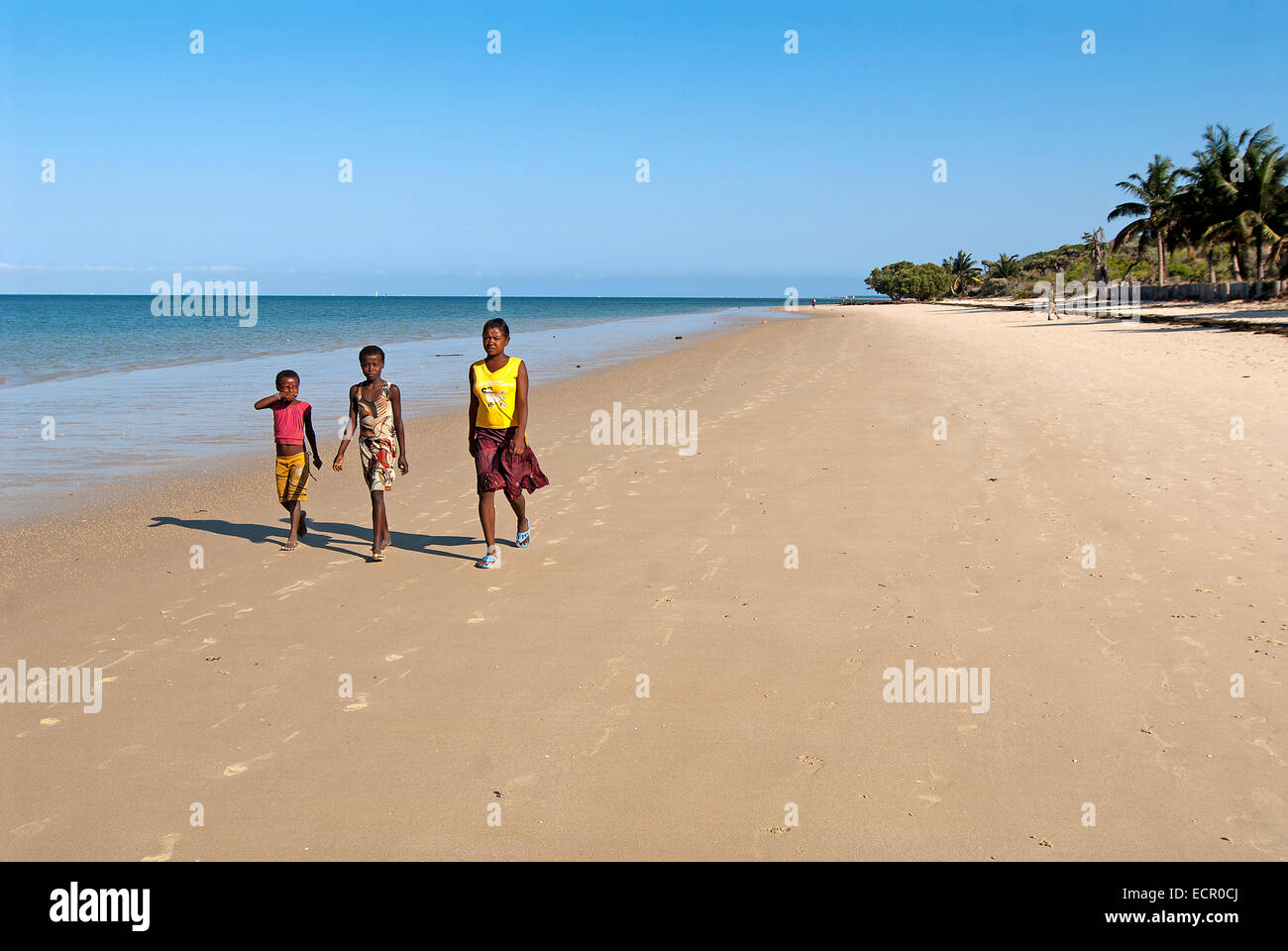 La popolazione locale a piedi lungo una spiaggia in Madagascar Foto Stock