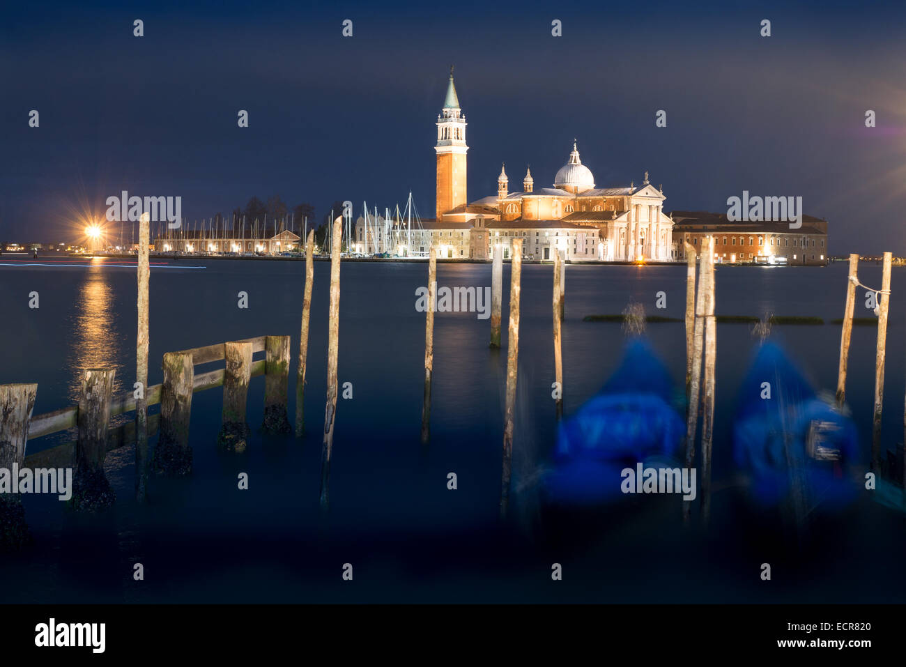 Basilica di San Giorgio Maggiore come si vede nelle ore notturne da dietro parcheggiato gondole in piazza San Marco, Venezia, Italia Foto Stock