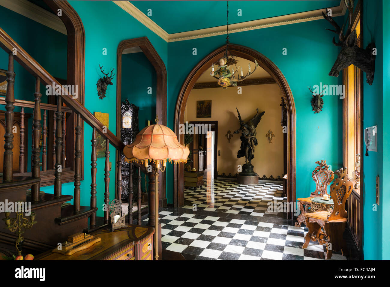 A scacchi il pavimento di marmo nella hall del castello con portali ad arco e le sculture in bronzo Foto Stock