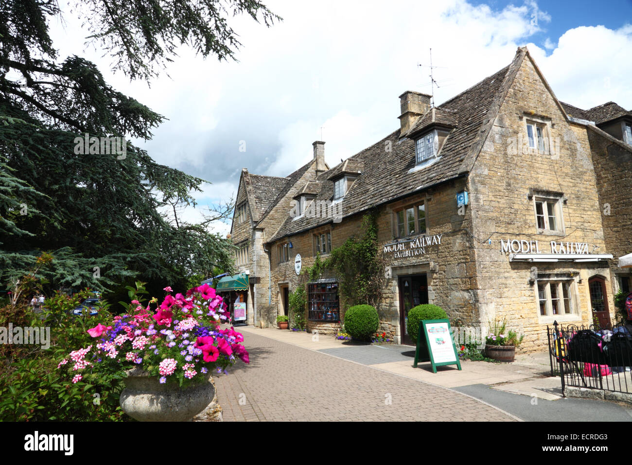 Un Cotswold casa di pietra con un modello ferroviario segno esposizioni. Foto Stock