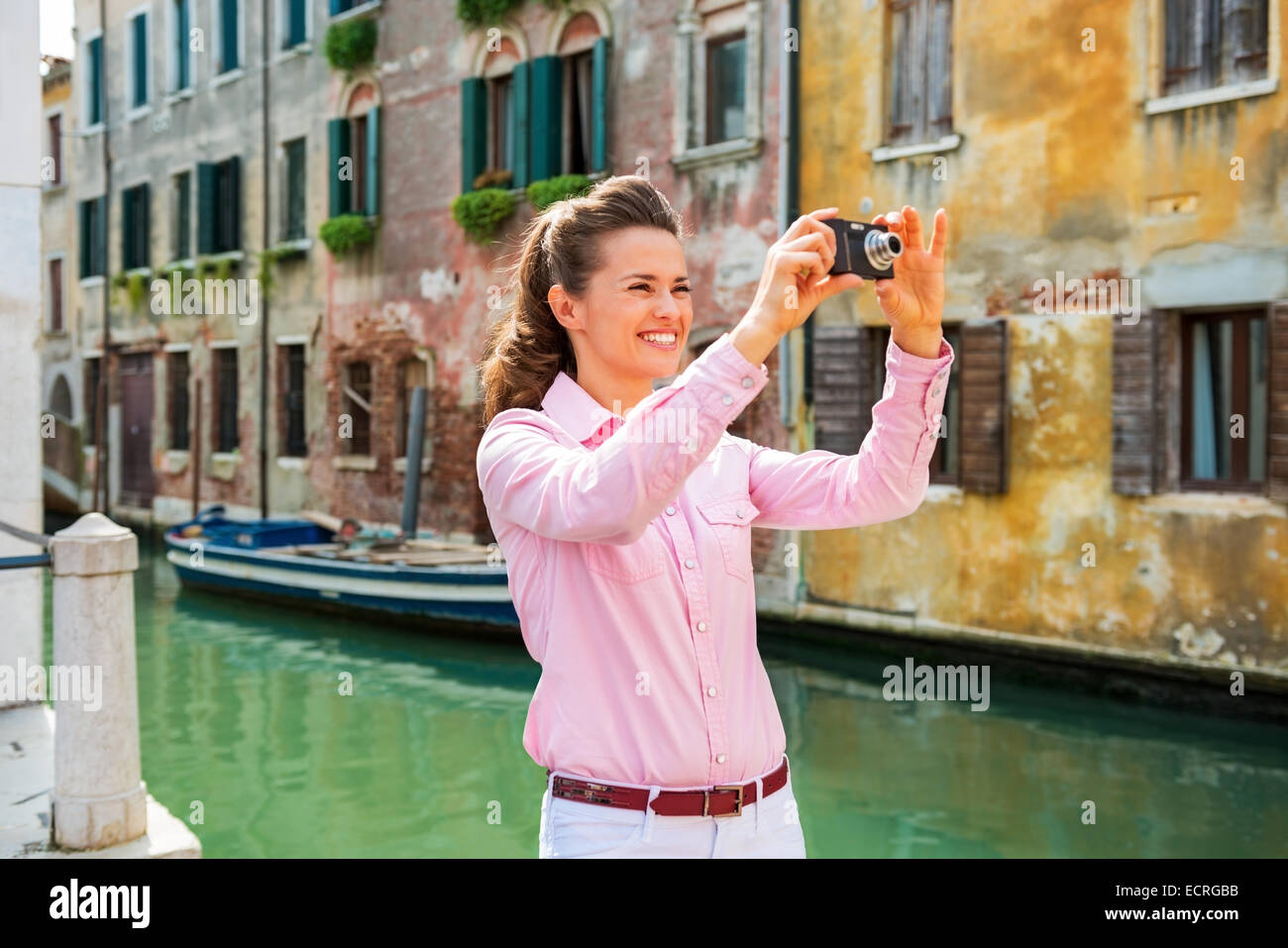 Felice giovane donna prendendo foto a venezia, Italia Foto Stock