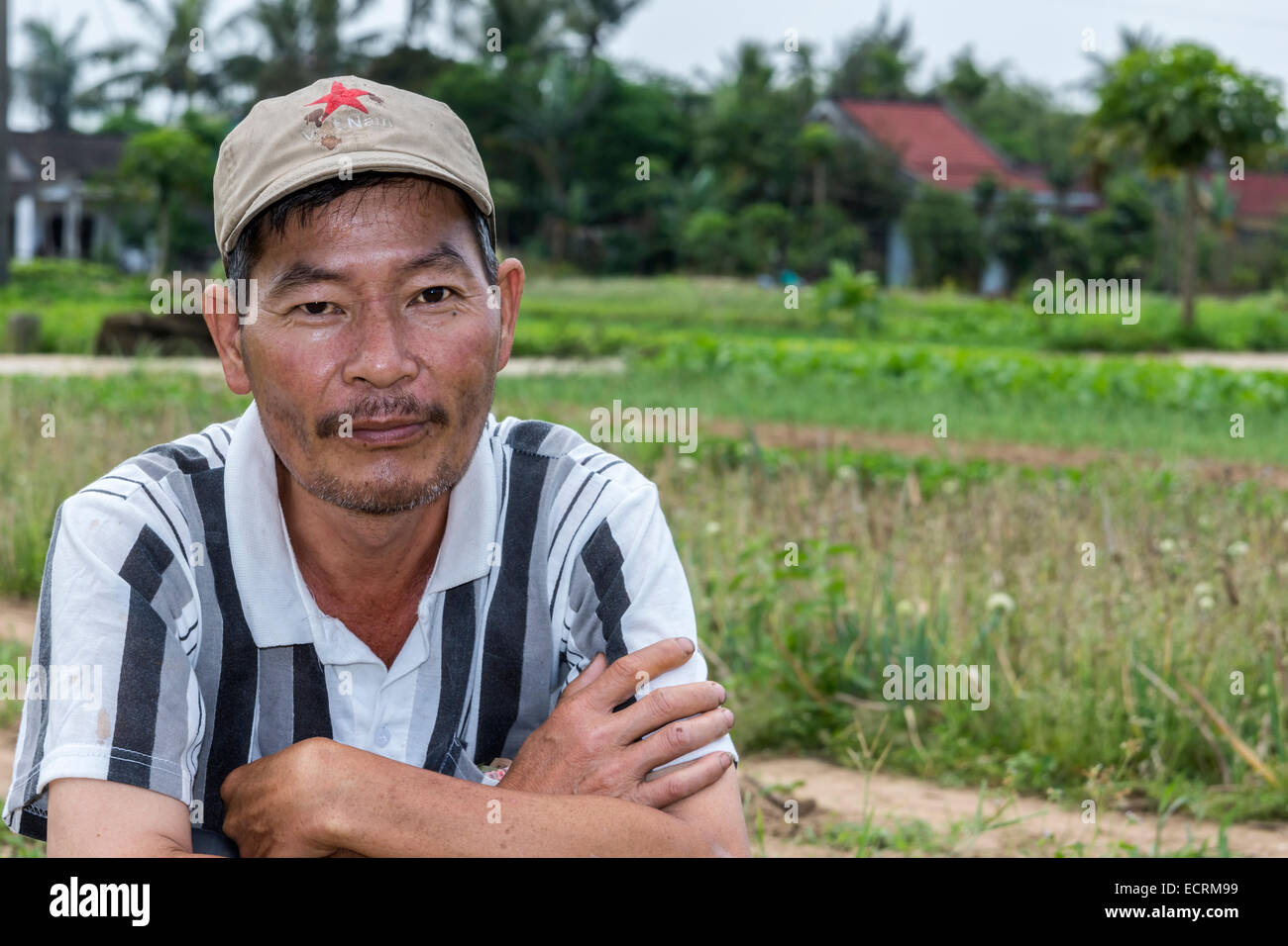 Giardiniere vietnamita guarda nella telecamera. Foto Stock