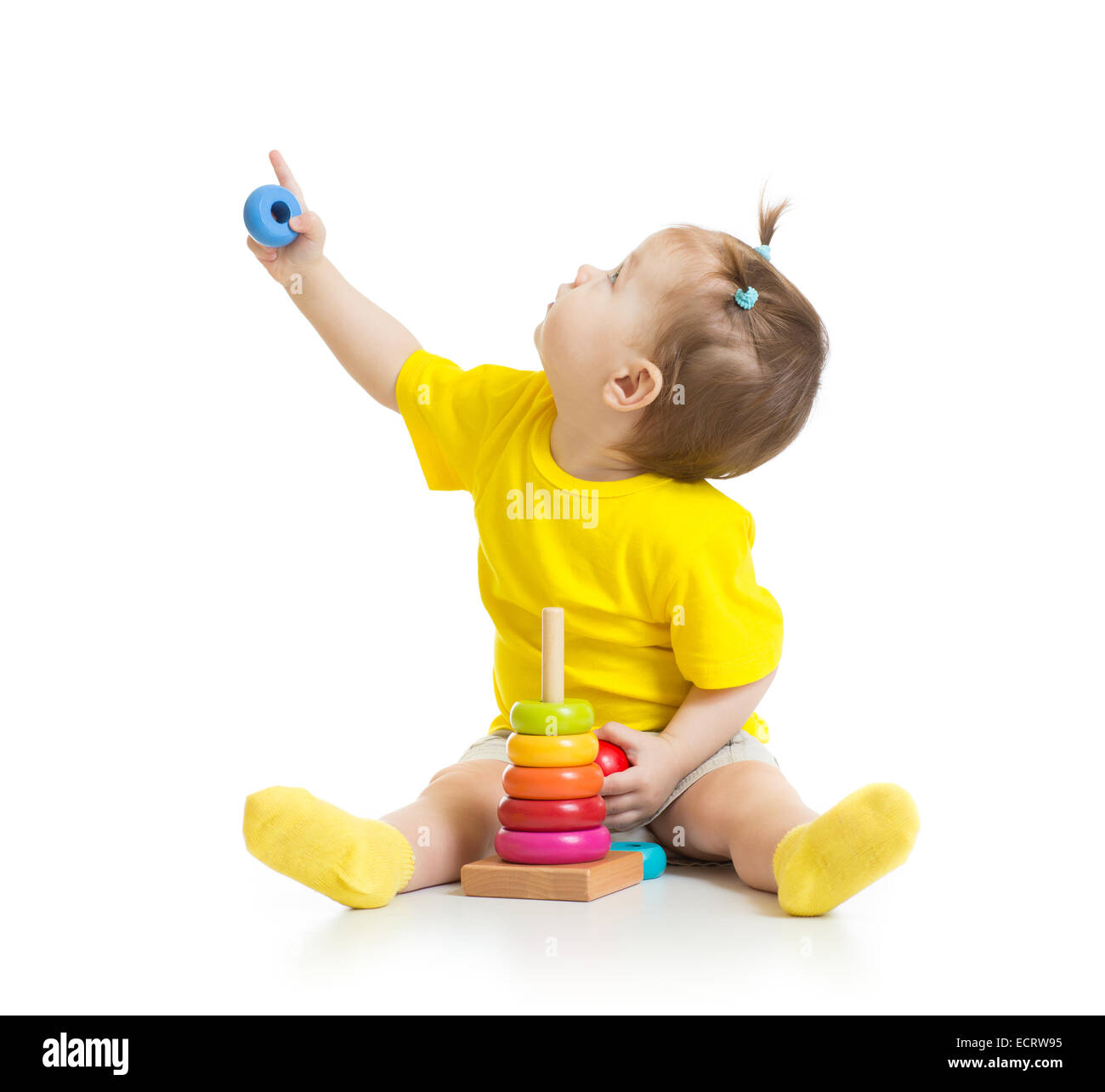 Il bambino gioca con colorati giocattolo e guardando in alto isolato su bianco Foto Stock