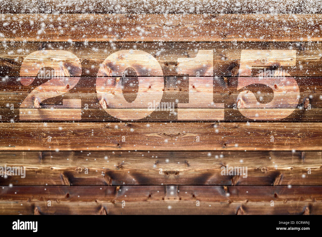 Tavola di legno con imbiancati fuori 2015 lettera e cadere soffici fiocchi di neve di diverse dimensioni Foto Stock