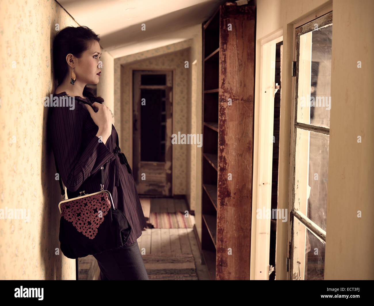 Moda ragazza detiene una borsetta e lei si appoggia sulla parete - retro camera, croce immagine elaborata Foto Stock