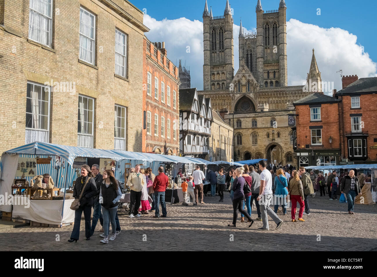 La gente che camminava round Lincoln piazza del mercato, con il Duomo in background, Lincolnshire, England Regno Unito Foto Stock