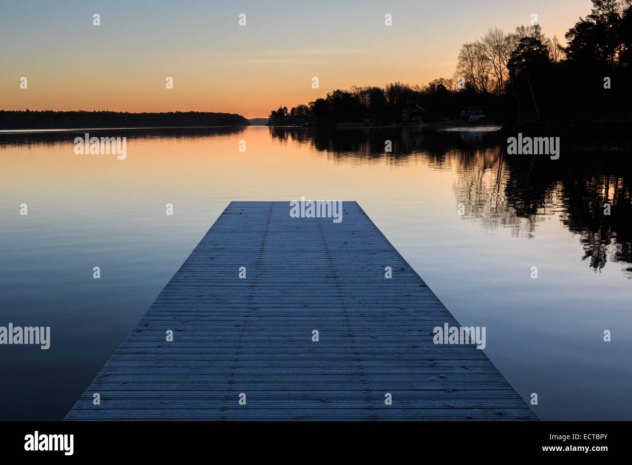 Paesaggio svedese con un pontile e acqua durante l'alba sunrise Foto Stock