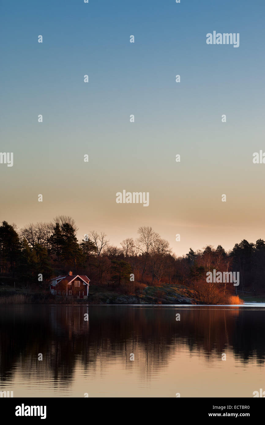 Paesaggio con cabina dal lago di prima mattina luminosa dawn a Stoccolma, Svezia. Foto Stock