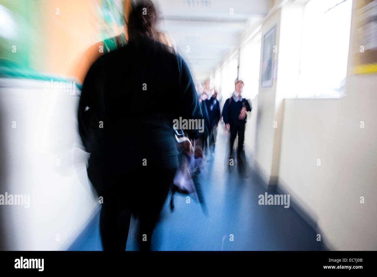 Istruzione secondaria Wales UK - immagine sfocata dei loro figli a scuola gli alunni correndo a piedi lungo un corridoio in tra lezioni Foto Stock