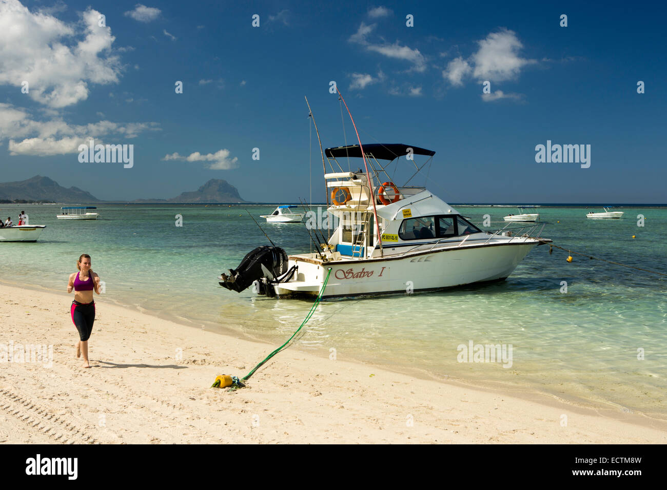 Maurizio, Flic en Flac, La Pirogue resort beach donna jogging passato Salvo 1 Sport Fishing Boat Foto Stock