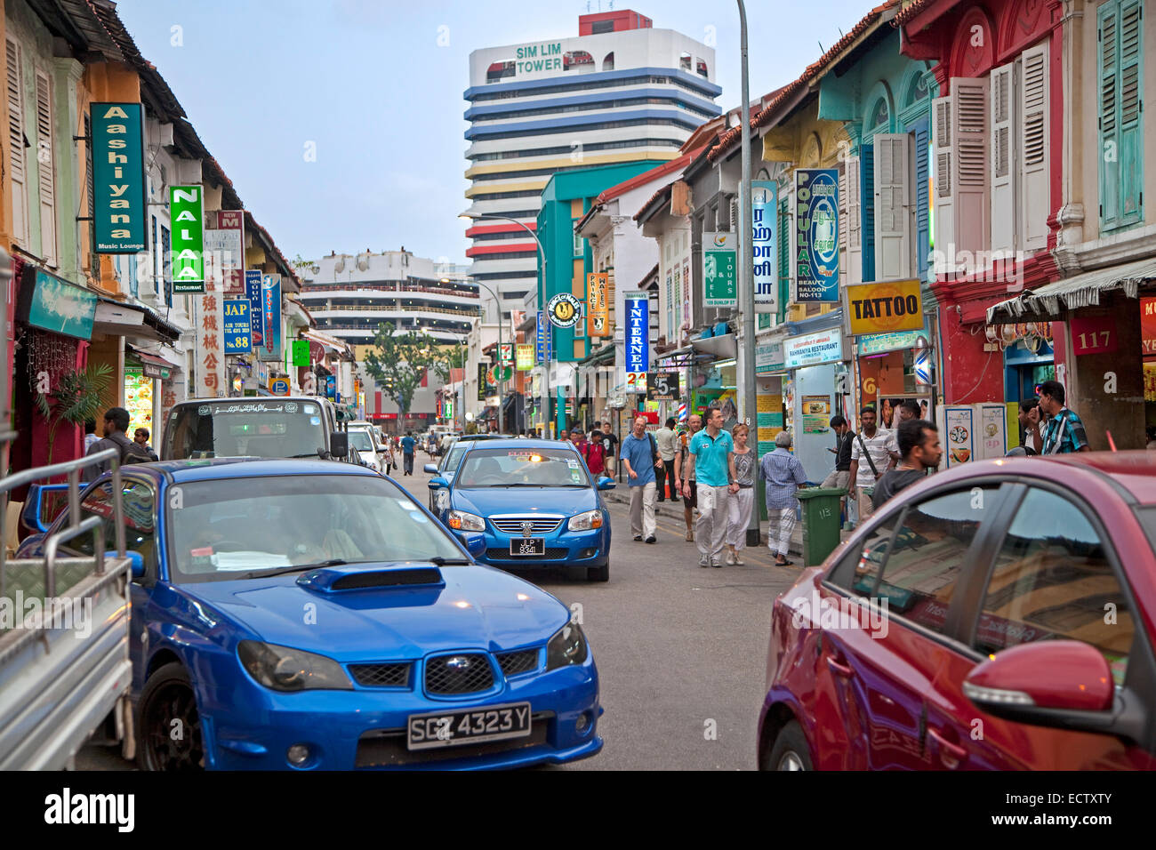 Turisti passato a piedi negozi colorati in Little India di Singapore Foto Stock