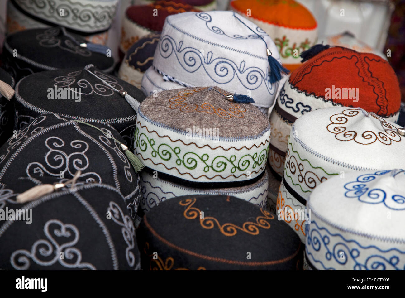 Tubeteikas tradizionali, maschio cappucci del Kirghizistan per la vendita al mercato in materia di SSL, Kirghizistan Foto Stock