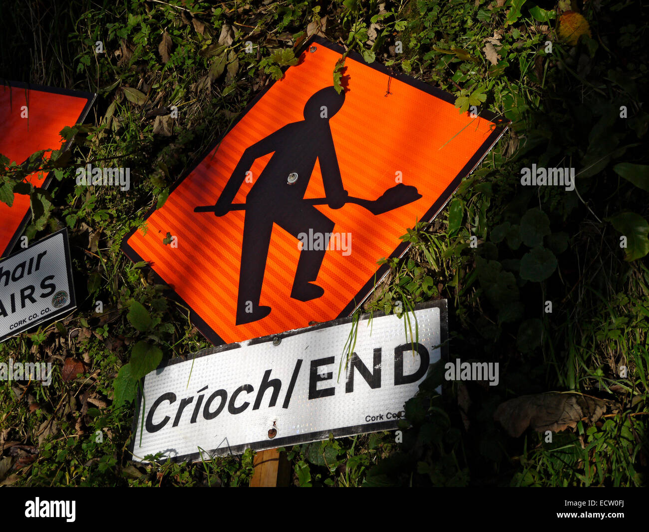 Bilingue (Irlandese - Inglese) opere stradali segno presso il villaggio di Aiohill, vicino Bandon County Cork, Irlanda. Foto Stock