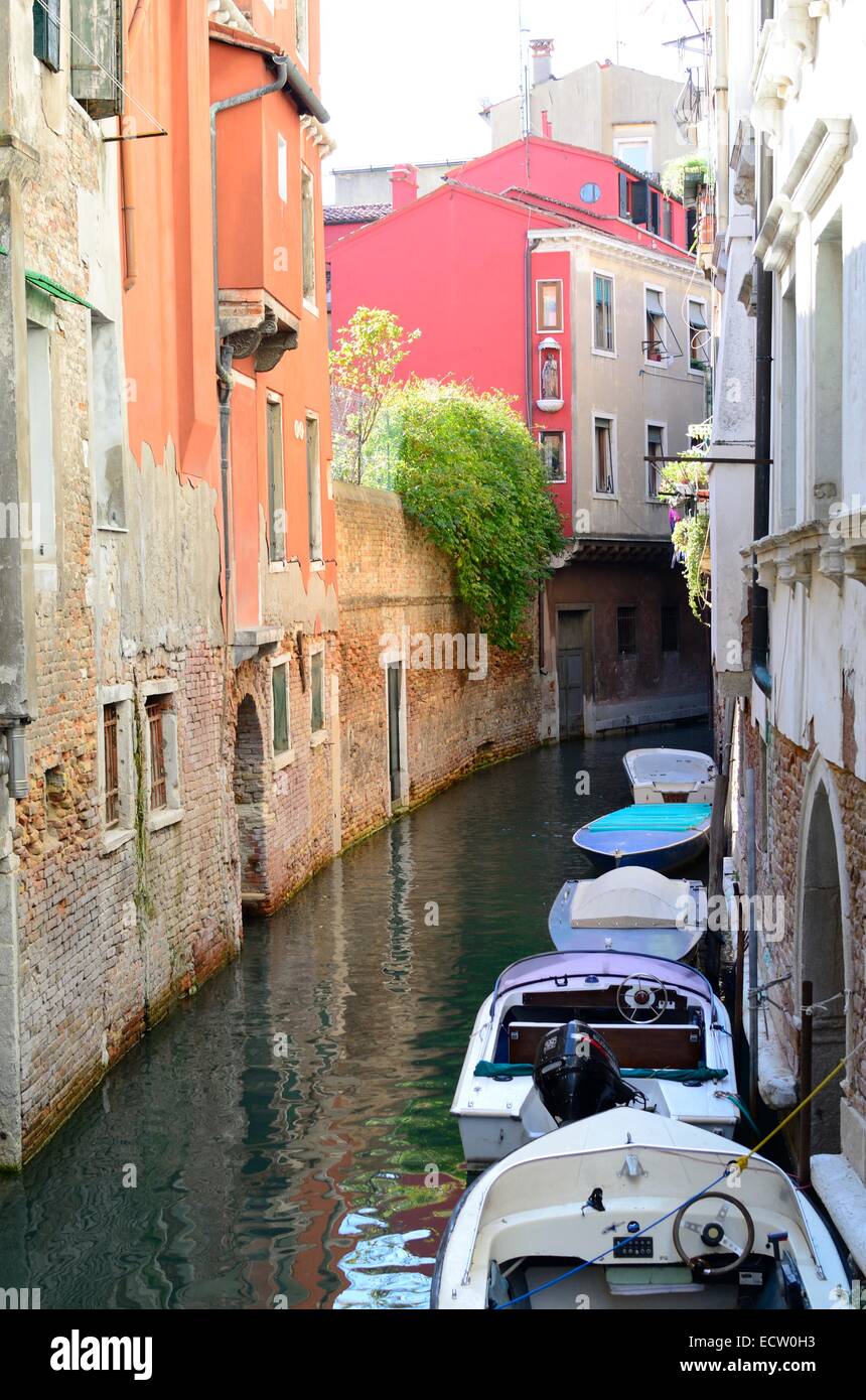 Speedboats parcheggiato su un colorful, tranquilla canal Venezia Foto Stock