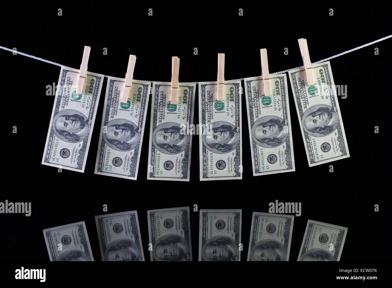 Sporco US dollar banconote pendenti da uno stendibiancheria e riflettendo in vetro Foto Stock