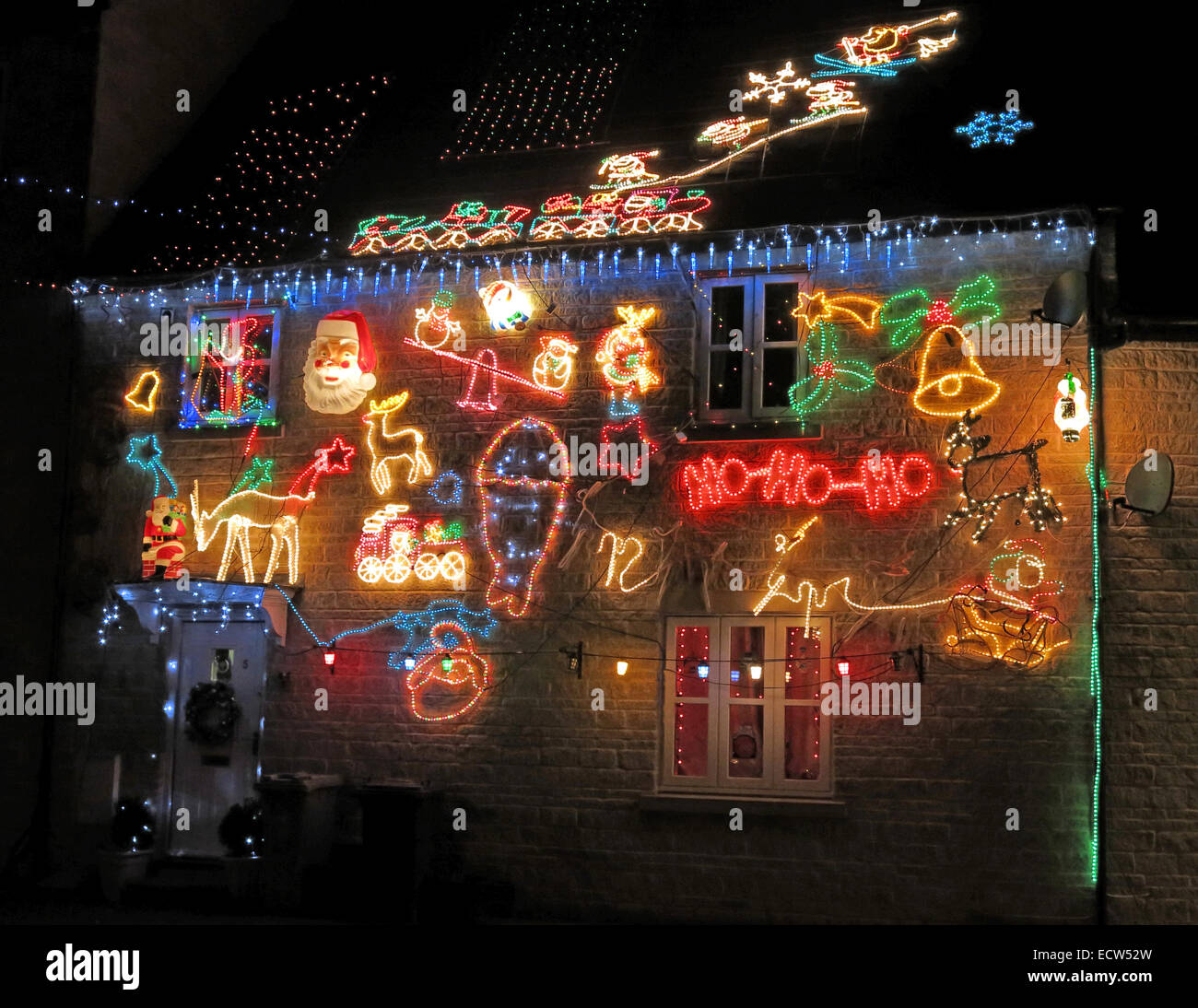 Luci di Natale in fase di overdone su una casa britannica - festeggiamenti in dicembre per Natale Foto Stock
