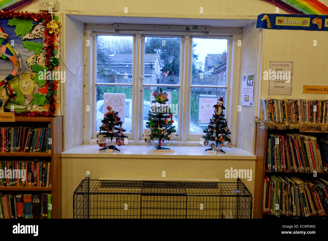 Tre piccoli bambini alberi di Natale nella finestra della Comunità Brighstone libreria durante la Brighstone albero di Natale Fest Foto Stock