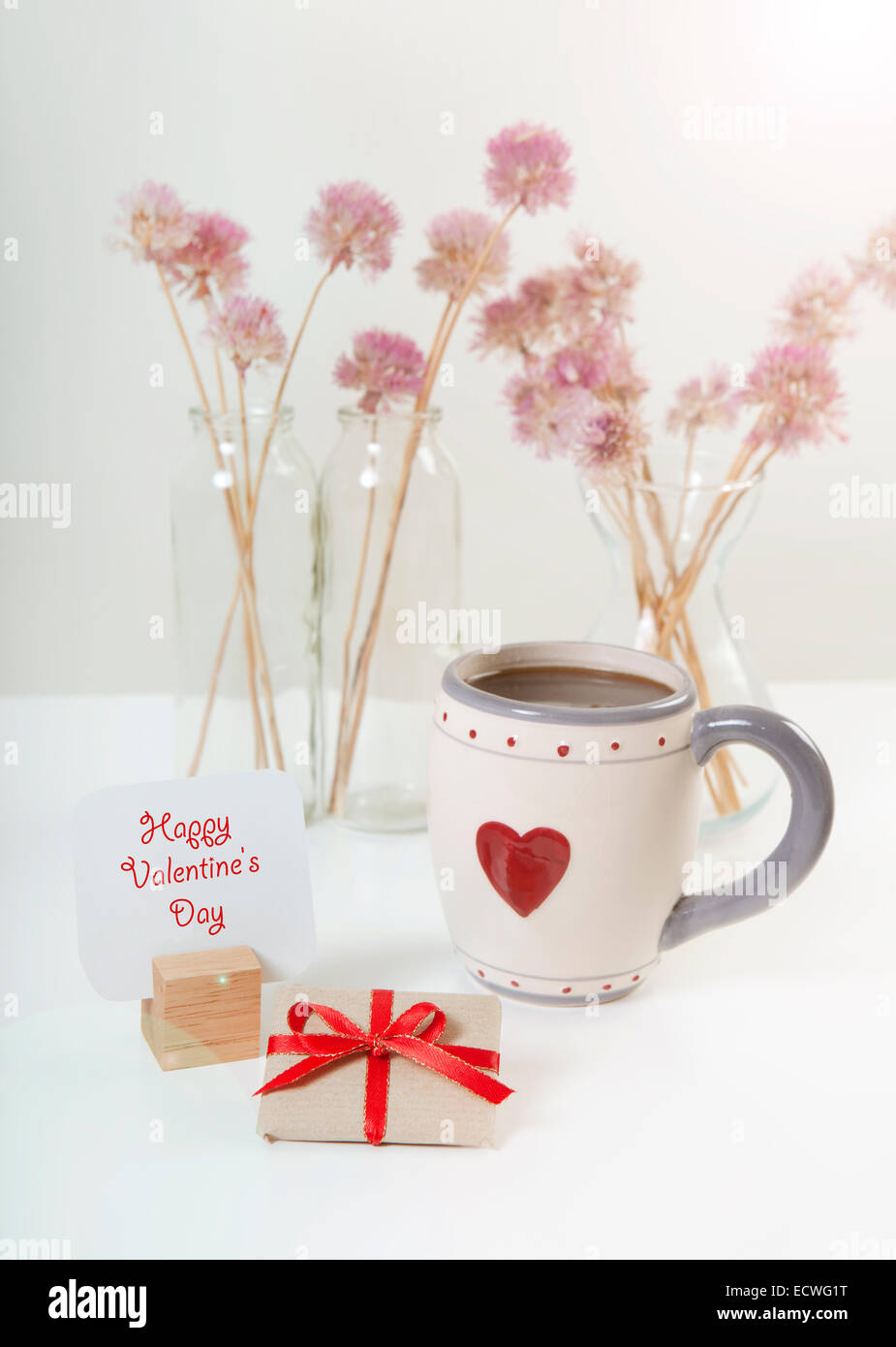 Un segno con il testo felice il giorno di San Valentino con un regalo e una tazza di caffè Foto Stock