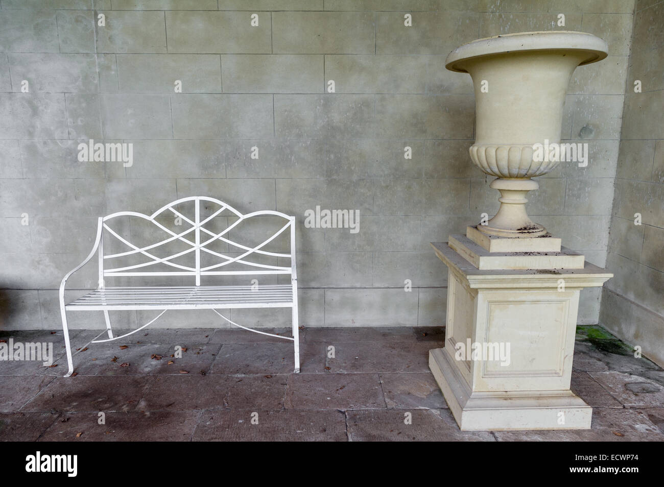 Ornati in metallo bianco banco a lato di una grande urna o fiore decorativo pot. Foto Stock