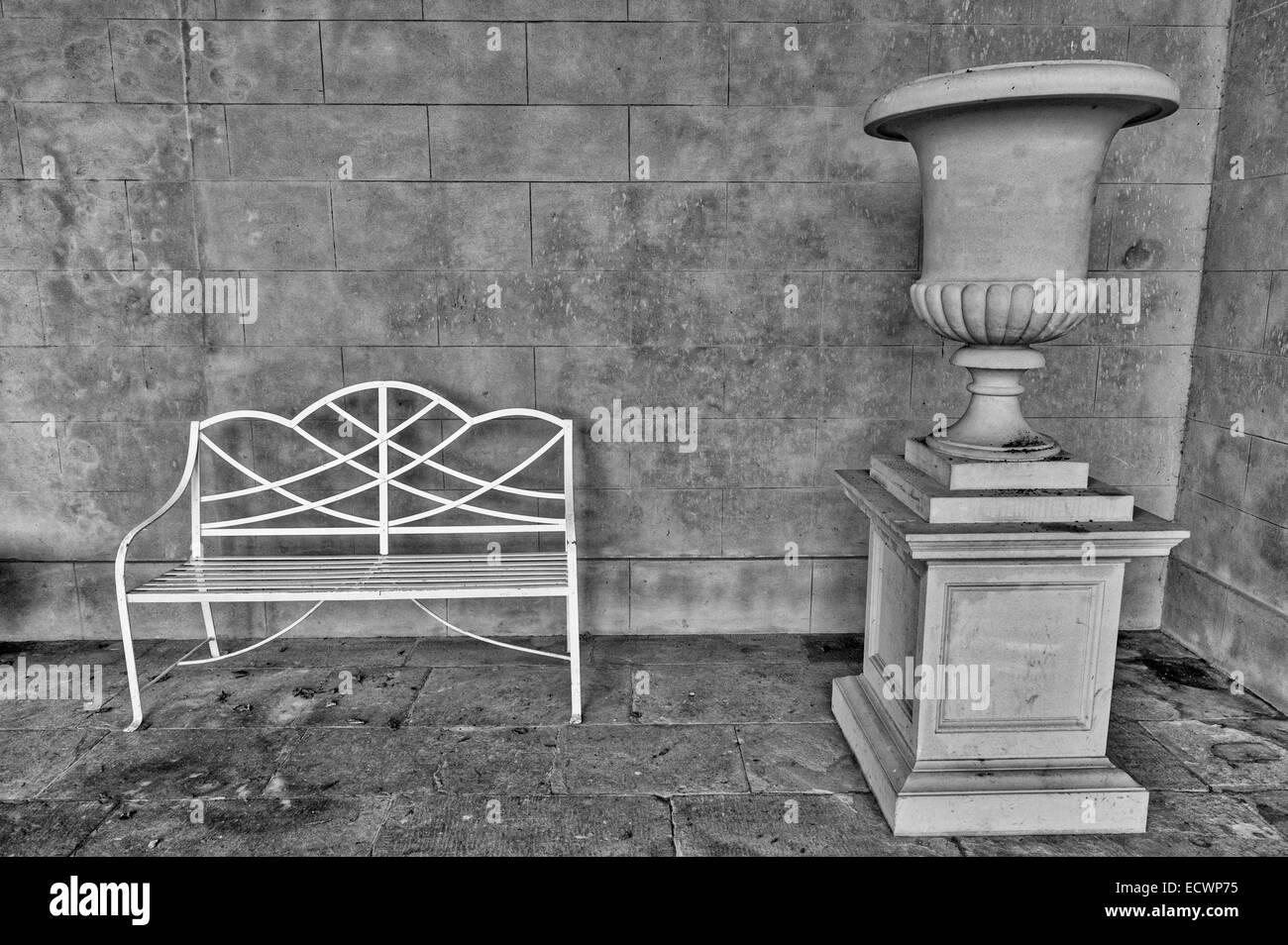 Ornati in metallo bianco banco a lato di una grande urna o fiore decorativo pot. Foto Stock