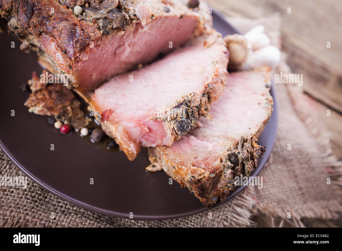 Arrosto di fette di carne su un sfondo di legno Foto Stock