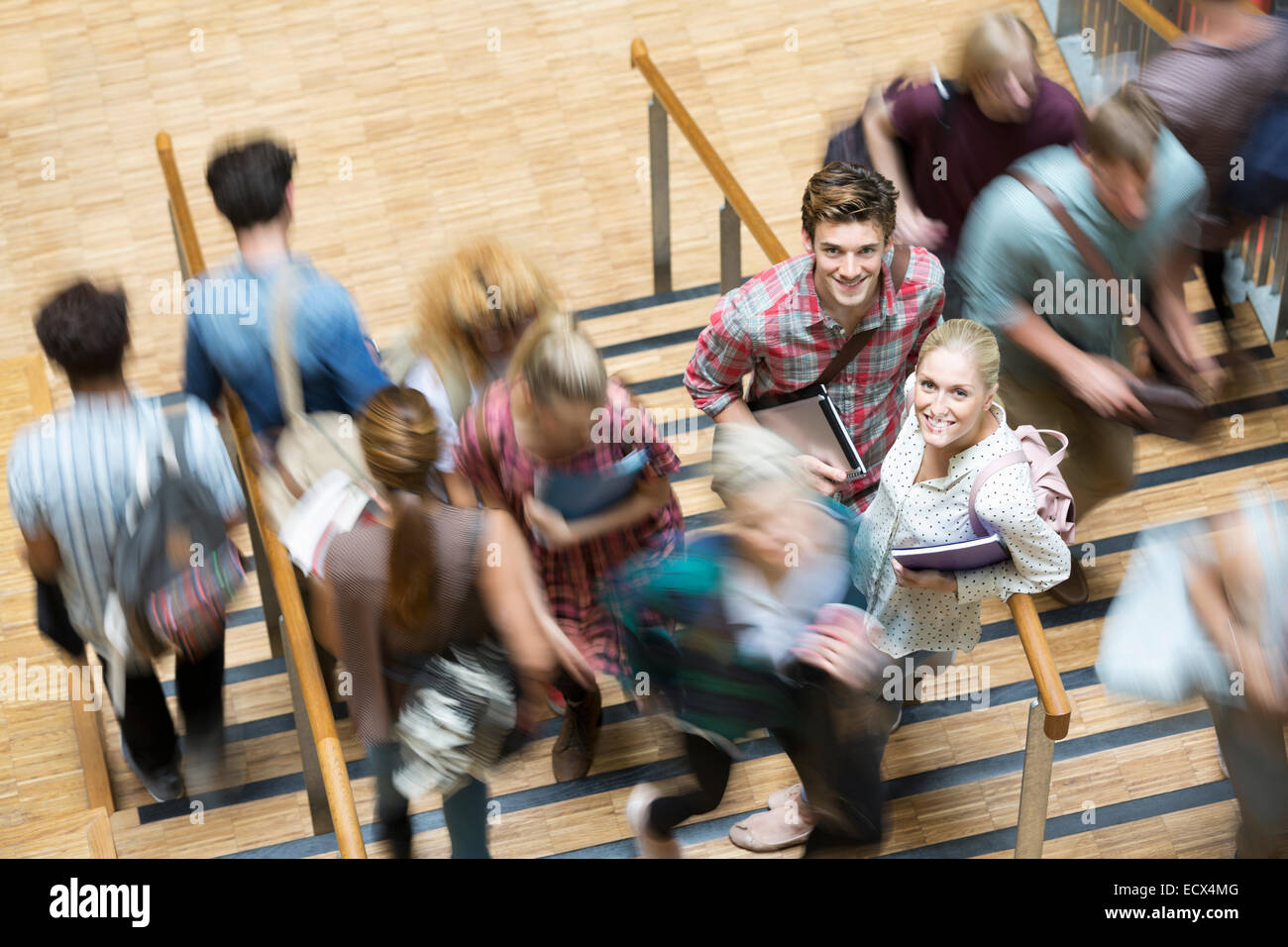 Gli studenti guardando la fotocamera e in piedi sulle scale durante il tempo di interruzione Foto Stock