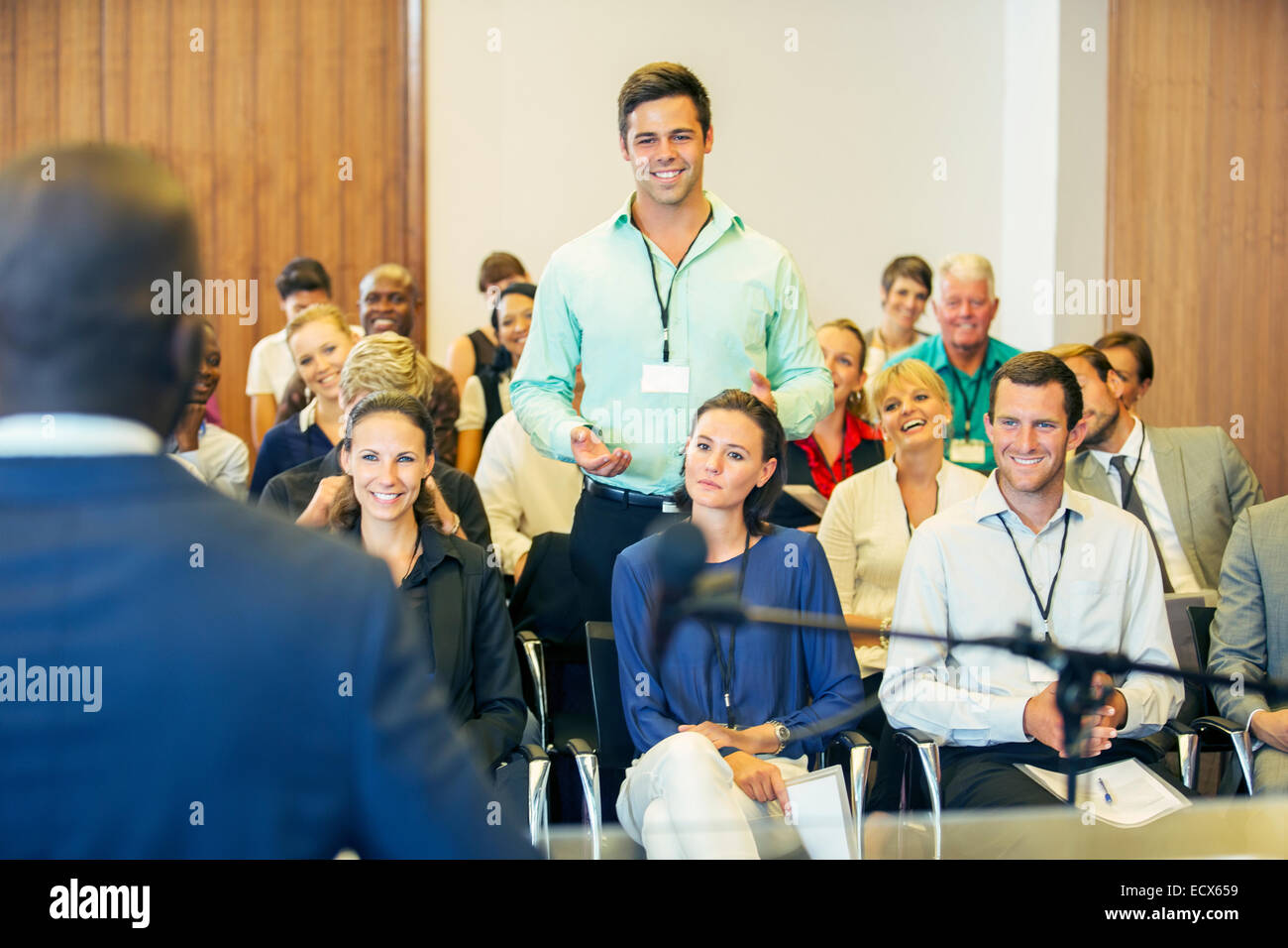 La gente di affari che frequentano la presentazione nella sala conferenze, sorridente e discutere Foto Stock