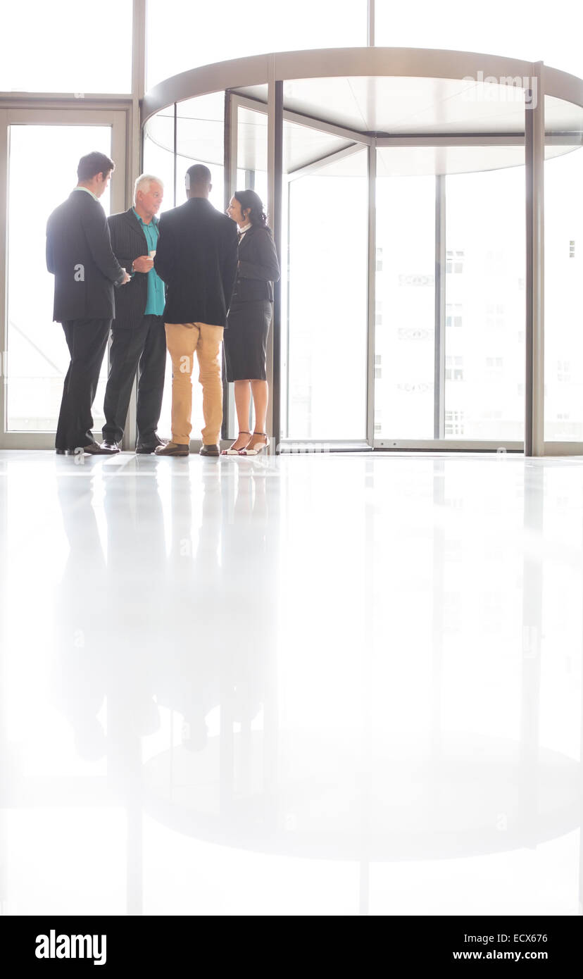 La gente di affari in piedi e parlare in prossimità della porta anteriore di office Foto Stock