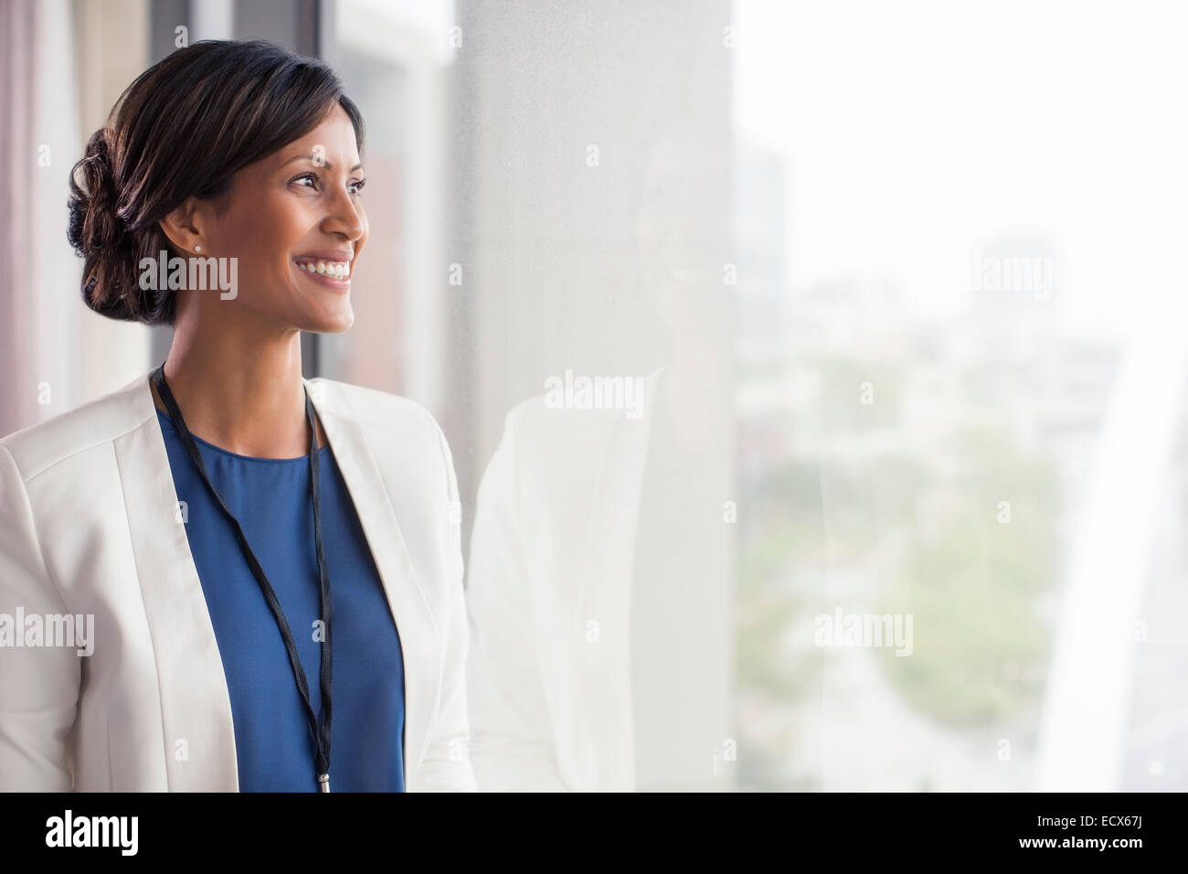 Ritratto di sorridere metà donna adulta guardando attraverso la finestra Foto Stock