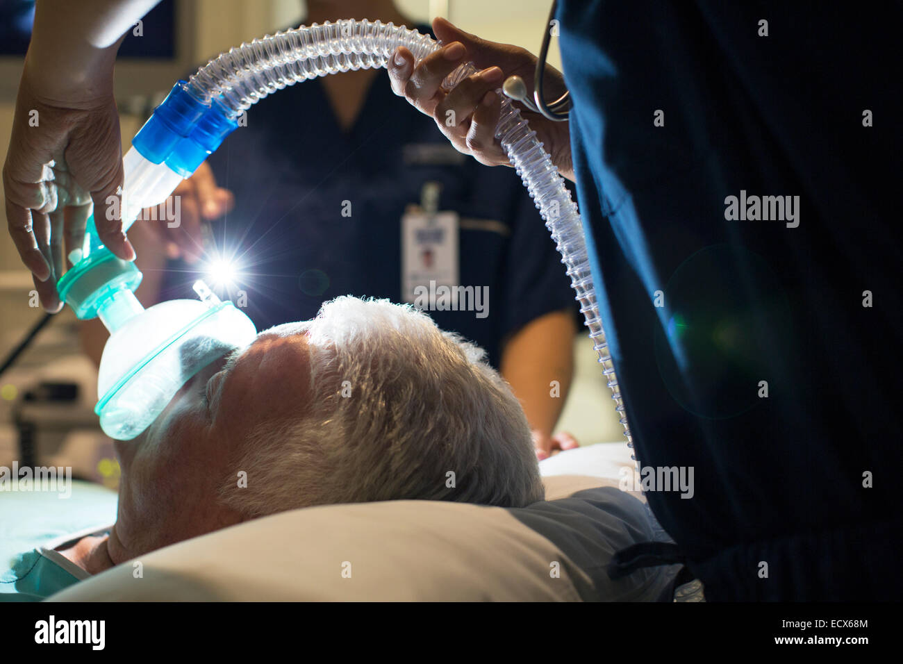Medico donna che indossa la maschera di anestesia mentre il paziente anziano in chirurgia Foto Stock