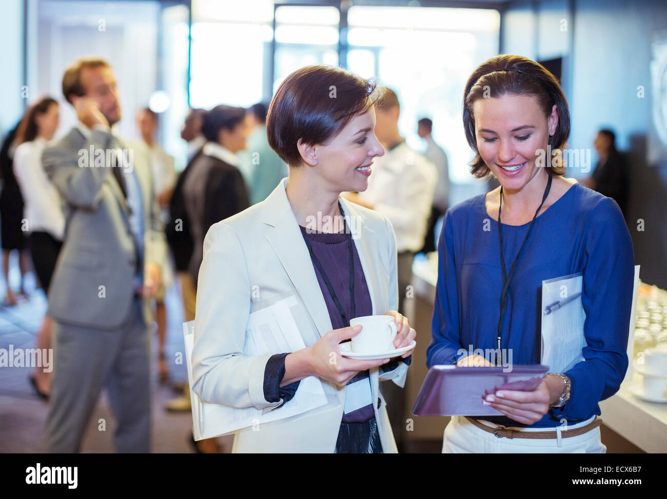 Ritratto di due donne sorridenti, parlando nella lobby del conference center durante la pausa caffè Foto Stock