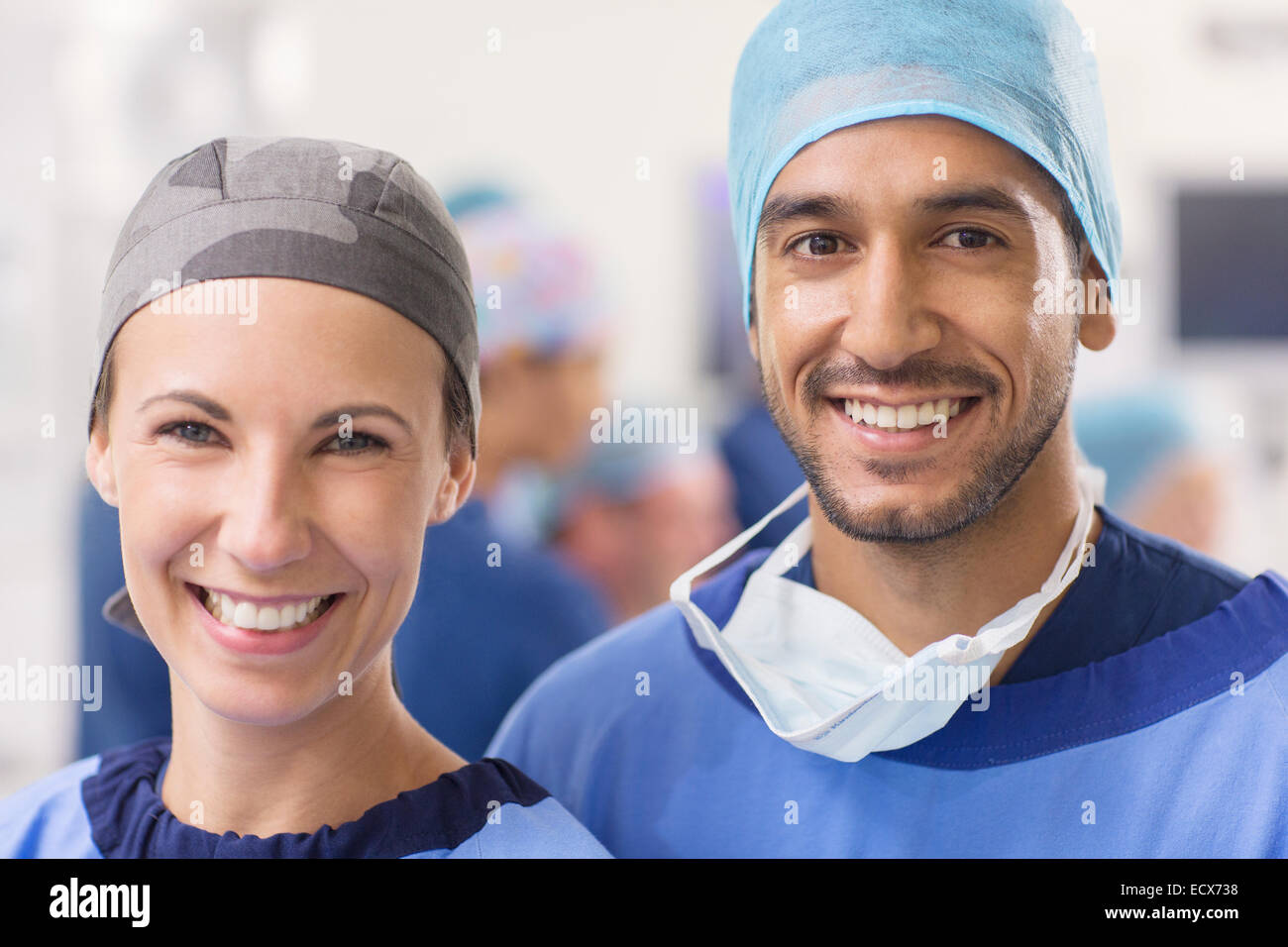 Ritratto di sorridere i medici indossano cappucci chirurgica in sala operatoria Foto Stock