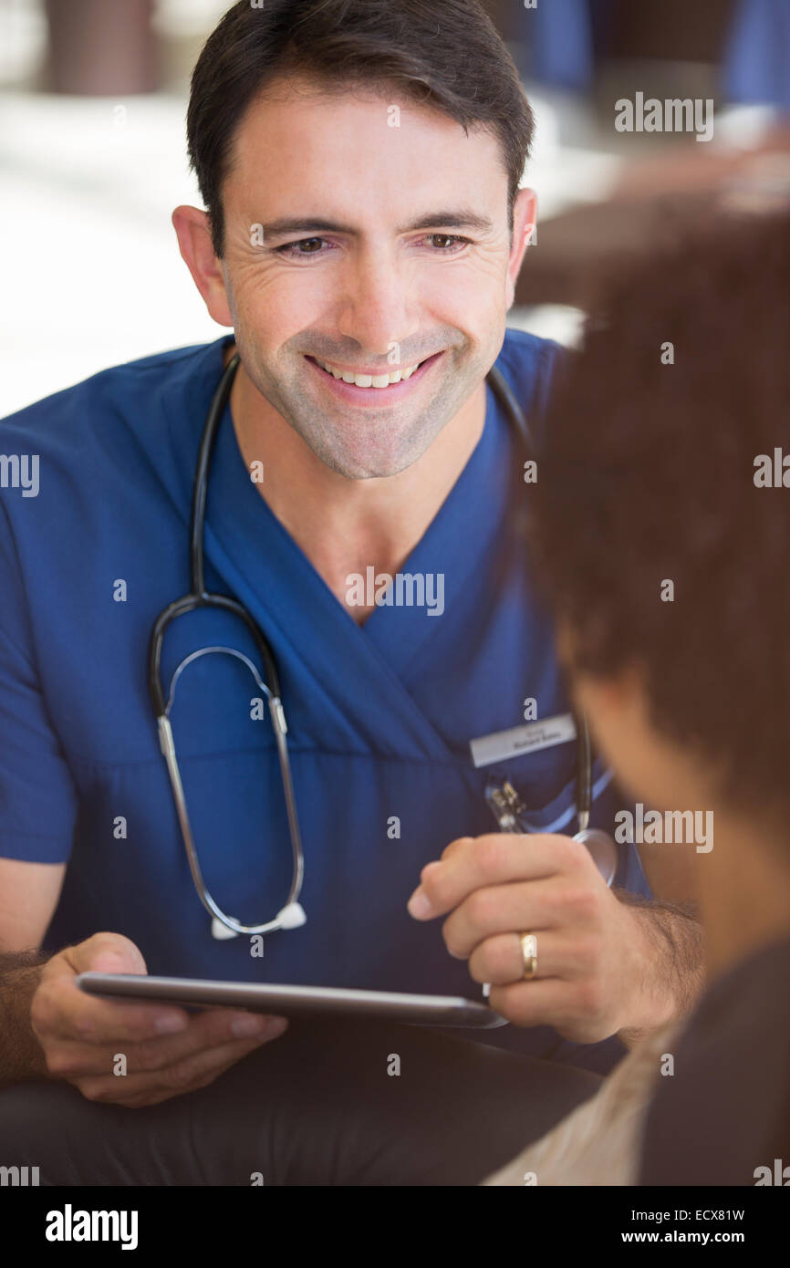 Ritratto di sorridere metà adulto medico tenendo un tablet pc Foto Stock