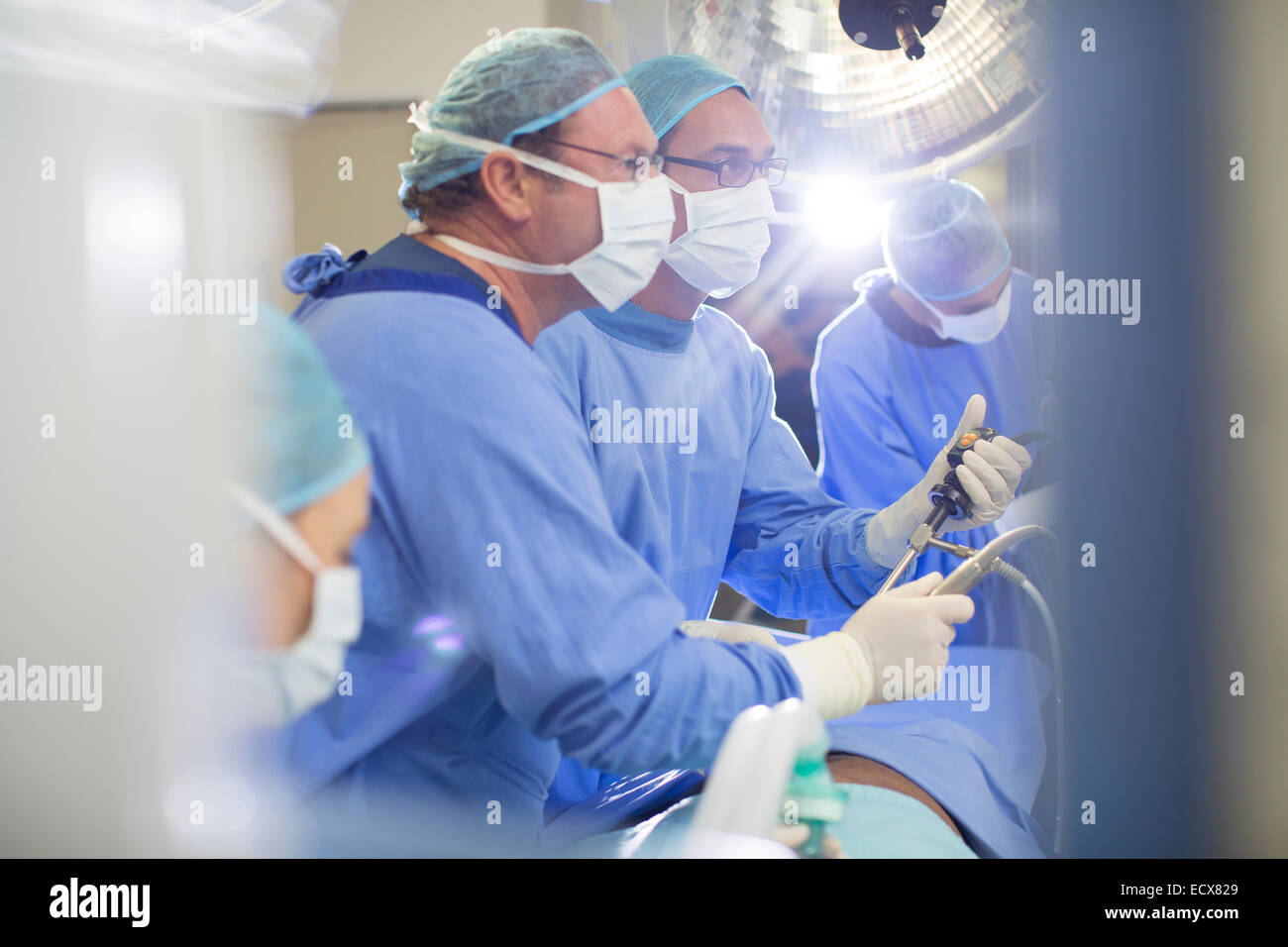 I medici di eseguire un intervento chirurgico in sala operatoria Foto Stock